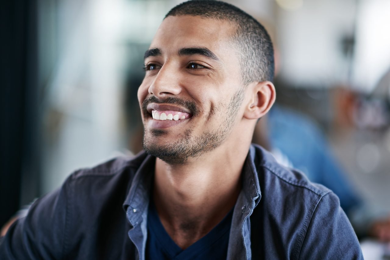 Young man smiling with his front teeth visible in a casual setting