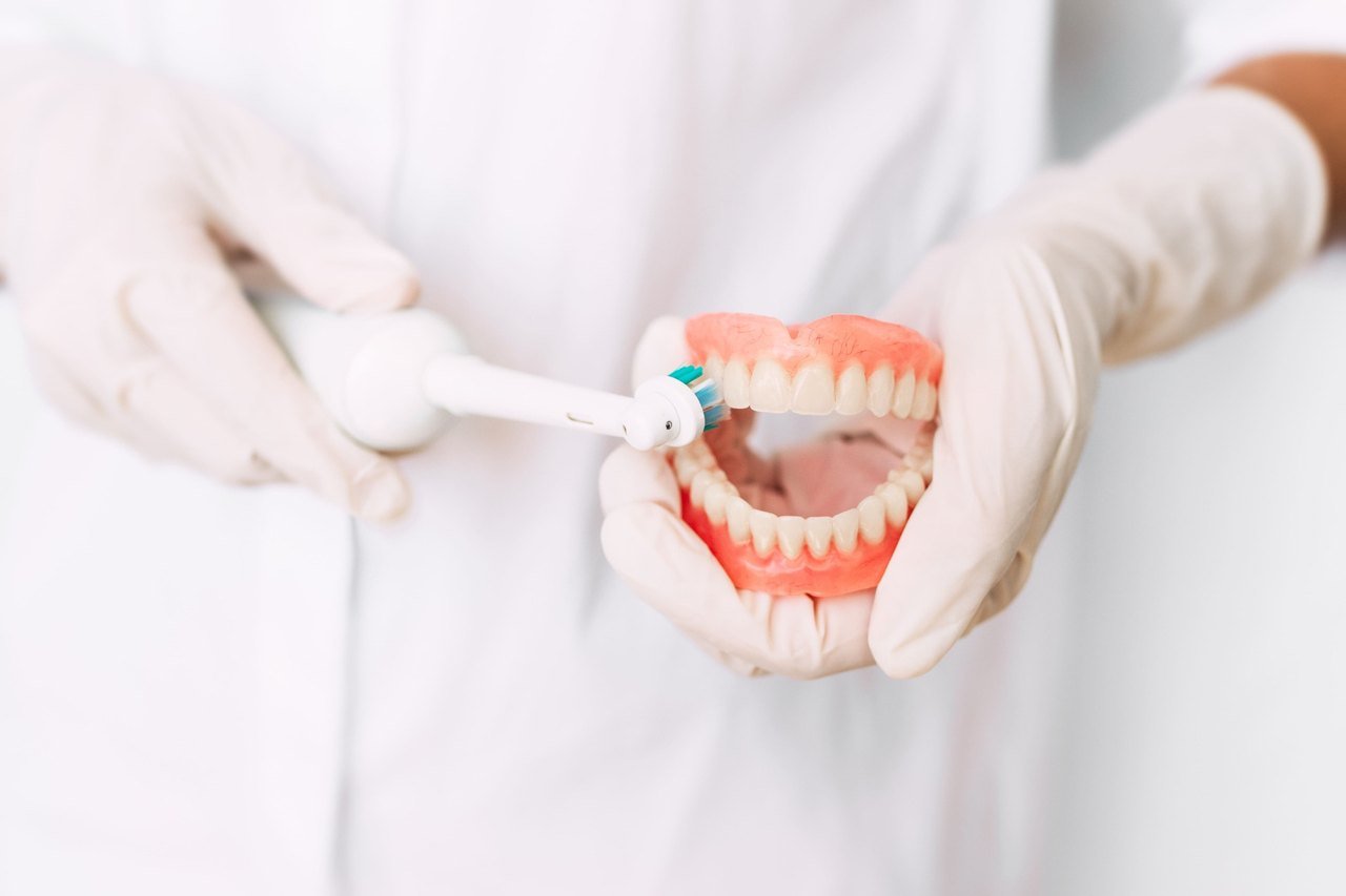 Dentist demonstrating proper brushing technique on a full dental model in Orlando