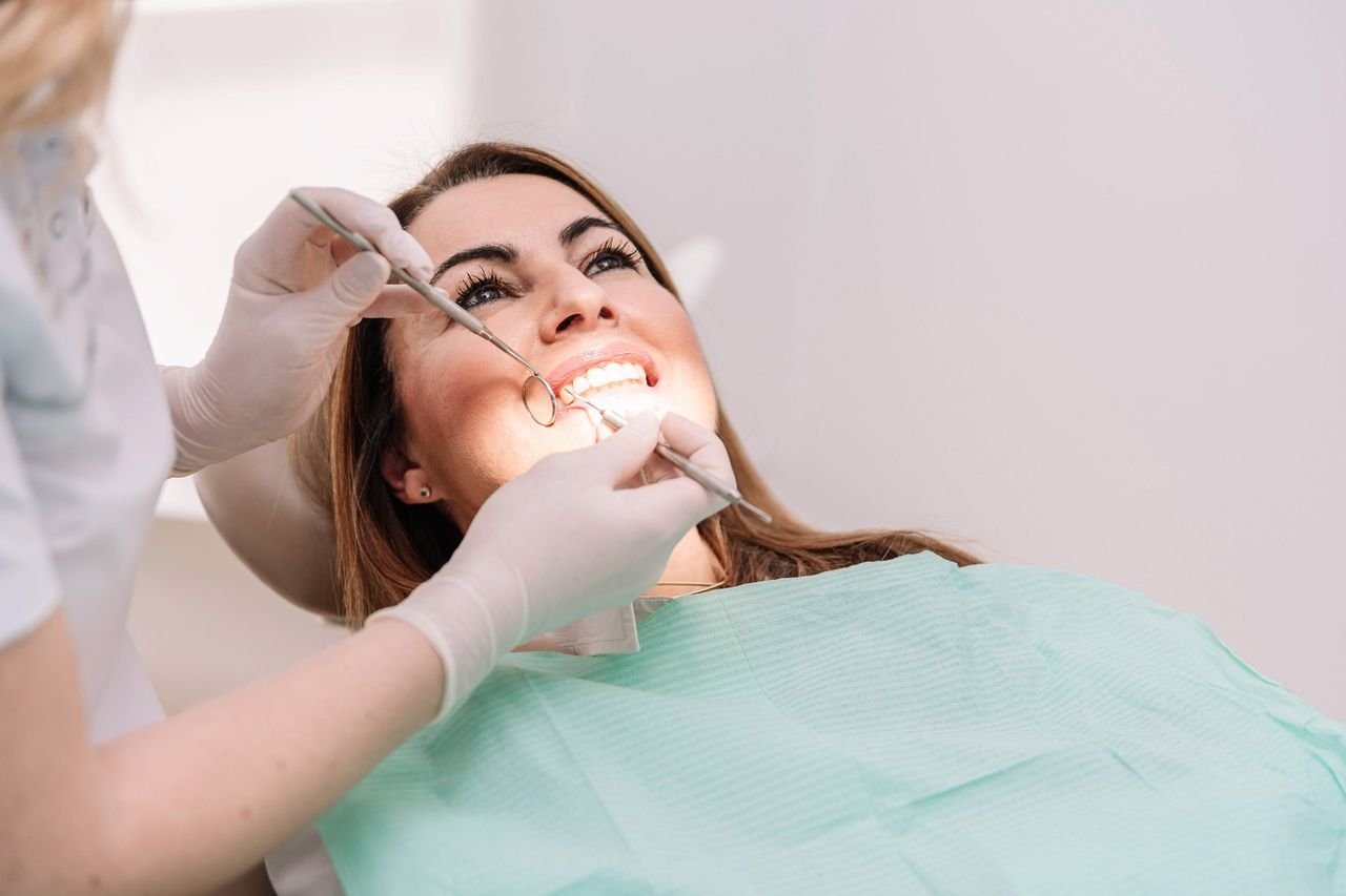 Gum changes are easiest to address early Dentist examining a smiling patient's teeth and gums at University Dental Group