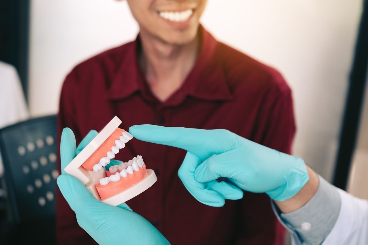 Knowing the stages helps you spot changes sooner Dentist using a dental model to explain gum health to a patient